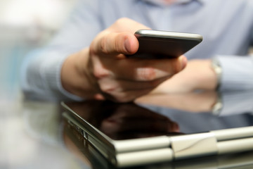 Business man working and analyzing financial figures on a graphs using laptop and mobile phone