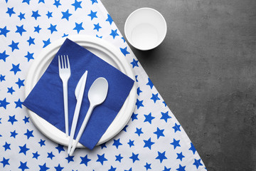 White plastic disposable tableware on gray background © Africa Studio