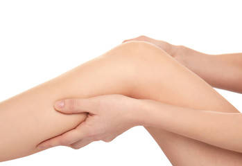 Young woman suffering from pain in leg on white background, closeup