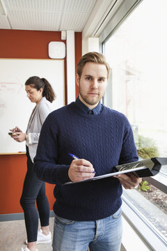 Sweden, Businessman holding ring binder in office