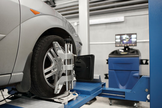 Grid sensor sets mechanic on auto. Car stand with sensors wheels for alignment camber check in workshop of Service station.