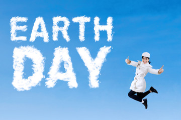 Young woman leaps with Earth Day text