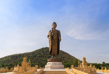 big bronze buddha statue standing in public wat thipsukhontharam temple Kanchanaburi thailand