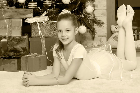 Little girl with gifts by the Christmas Tree
