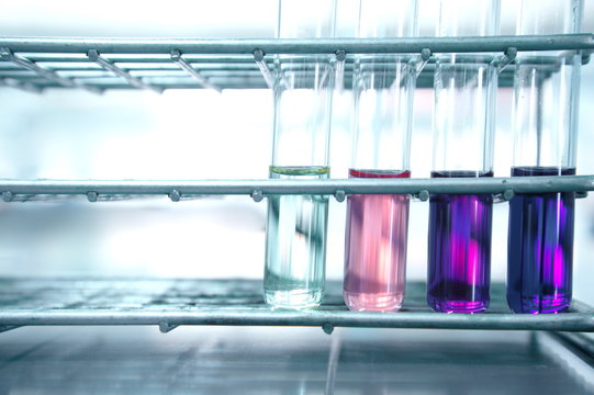 pink and purple test tube in metal steel rack on science laboratory