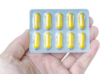 Man holding pack of yellow pills isolated on white