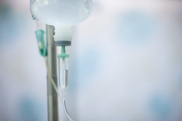 A bottle of saline is hung on the rail to pass through the hose for treating the patient.
