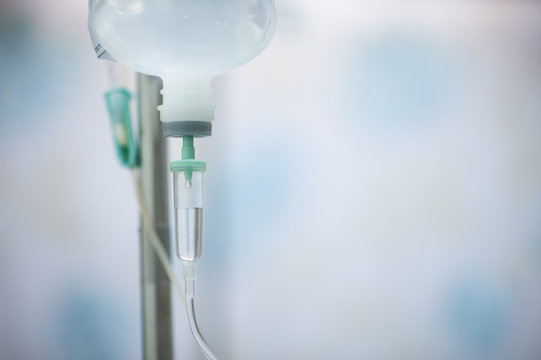 A bottle of saline is hung on the rail to pass through the hose for treating the patient.