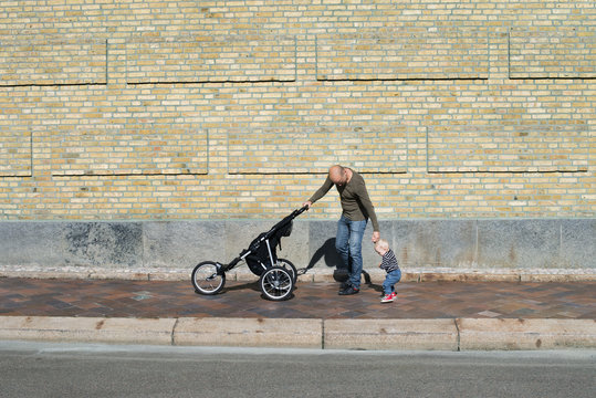 Sweden, Father and baby son (12-17 months) walking with stroller
