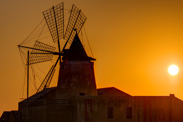 Windmill at sunset at the saltpans of Marsala in Sicily