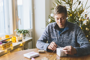 Finland, Man wrapping christmas gifts