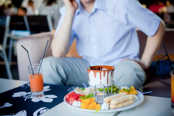 chocolate fondue with fruits in blue pot