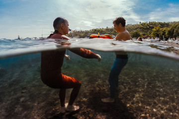 Freedivers training static breath hold in shallow water of a calm bay. Coach watching student