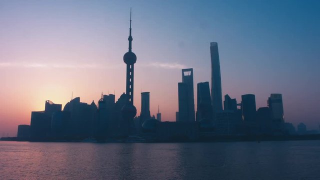 Sun in showing from behind the building in Shanghai central business district. No ships. 4K UHD