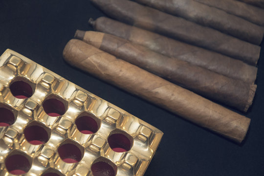 group of cigars on black background with ash tray