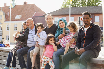 Sweden, Blekinge, Solvesborg, Portrait of family with children (2-3, 4-5, 6-7) sitting on brick wall