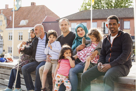 Sweden, Blekinge, Solvesborg, Portrait of family with children (2-3, 4-5, 6-7) sitting on brick wall