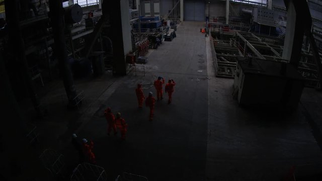  Team of workers at fuel plant come up from underground & walk into daylight