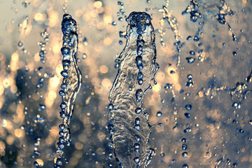 drops of the fountain in the setting sun.