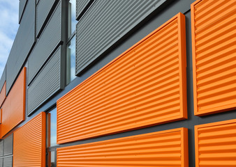 Architectural background. Wall of the modern orange and black corrugated metal panels. - 143385813