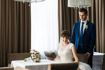 Obraz na płótnie Canvas bride and groom in restaurant near the table
