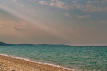 cloudy evening sky on the shore of an undulating turquoise sea in the spring of April.