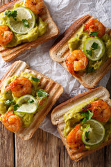 tasty Mexican sandwiches with guacamole, prawns and lime close-up. vertical top view