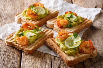 tasty Mexican sandwiches with guacamole, prawns and lime close-up. horizontal