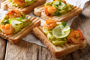Mexican sandwiches with guacamole, prawns and lime close-up. horizontal
