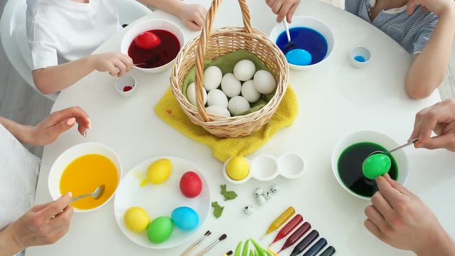 mother, dad and their sons are painting eggs. Happy family are preparing for Easter.