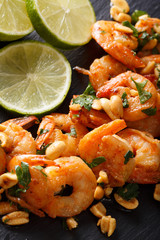 Sauteed shrimp with peanuts, lime and greens macro. vertical