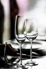 Empty glasses for champagne and wine are on the table in a row.