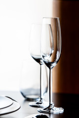 Empty glasses for champagne and wine are on the table in a row.