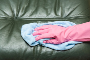 Leather sofa cleaning with rag. Upholstered furniture. Early spring cleaning or regular clean up.