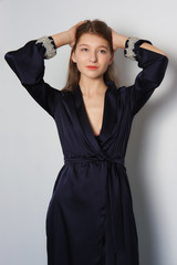 Fototapeta premium Attractive fashion model in long silk dress touching hair.