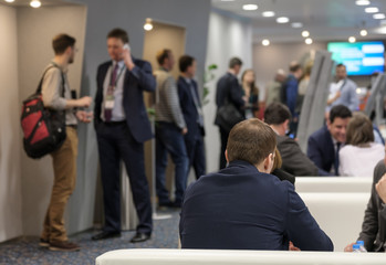 Business people conduct conversations during a break of the conference