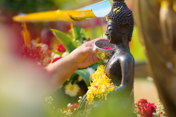 water pouring to Buddha statue in Songkran festival tradition of thailand