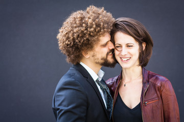 Mann flüstert seiner Freundin etwas zu