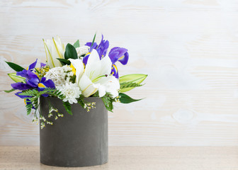 Floral arrangement of fresh flowers on a wooden background with space for text