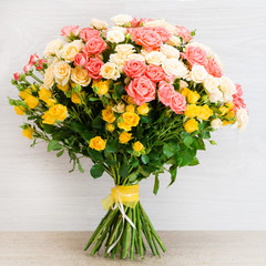 Beautiful bouquet of bush roses on a wooden background