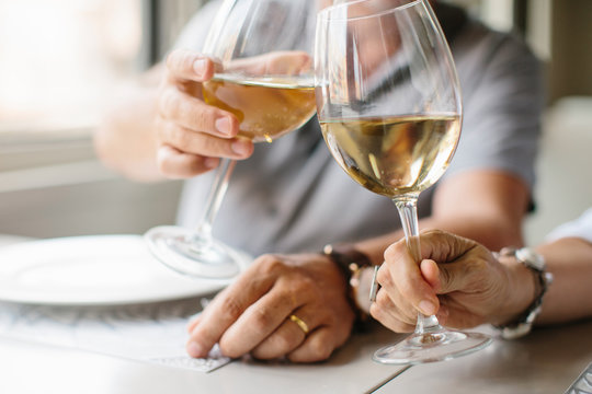 Crop shot of people clinking wineglasses