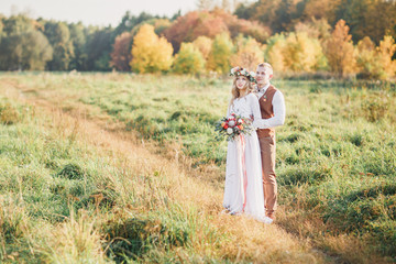 Groom and bride hugging on a meadow. Summer wedding outdoors.