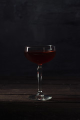 Hot mulled wine on a wooden table over dark background right