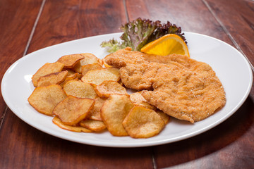 Plate with fried poultry breast with fried potatoes