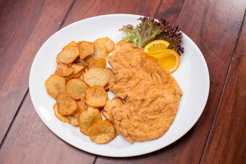 Plate with fried poultry breast with fried potatoes