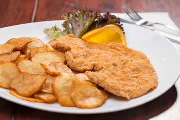 Plate with fried poultry breast with fried potatoes
