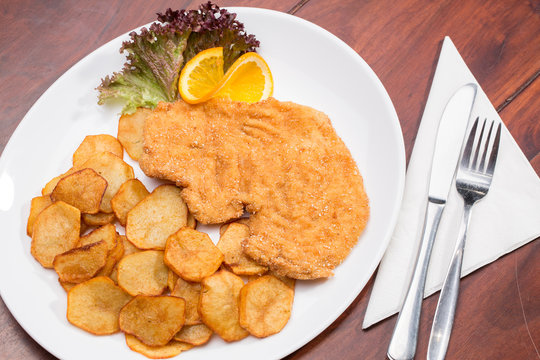 Plate with fried poultry breast with fried potatoes