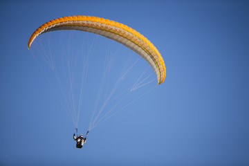 Paraglider flying over mountains.