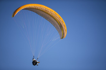 Paraglider flying over mountains.