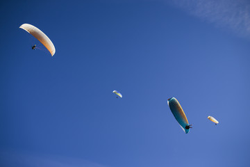 Paraglider flying over mountains.